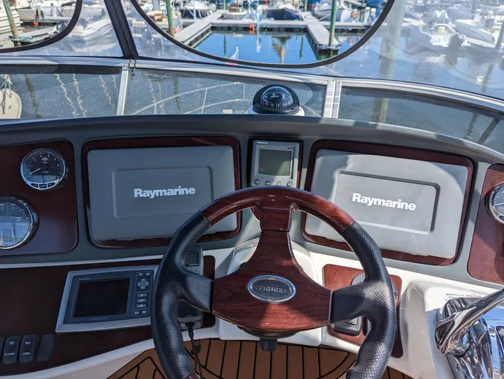 Lady C Yacht Photos Pics Cockpit view of 2011 Meridian 341 Sedan with Raymarine navigation systems and wooden steering wheel.