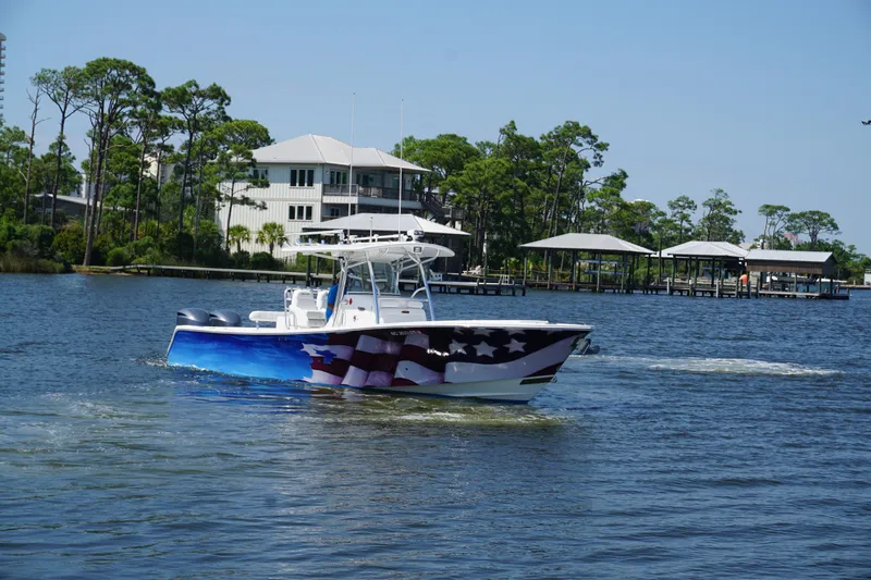 Past Time Yacht Photos Pics 2012 Regulator 32 Forward Seating boat with American flag design on water.