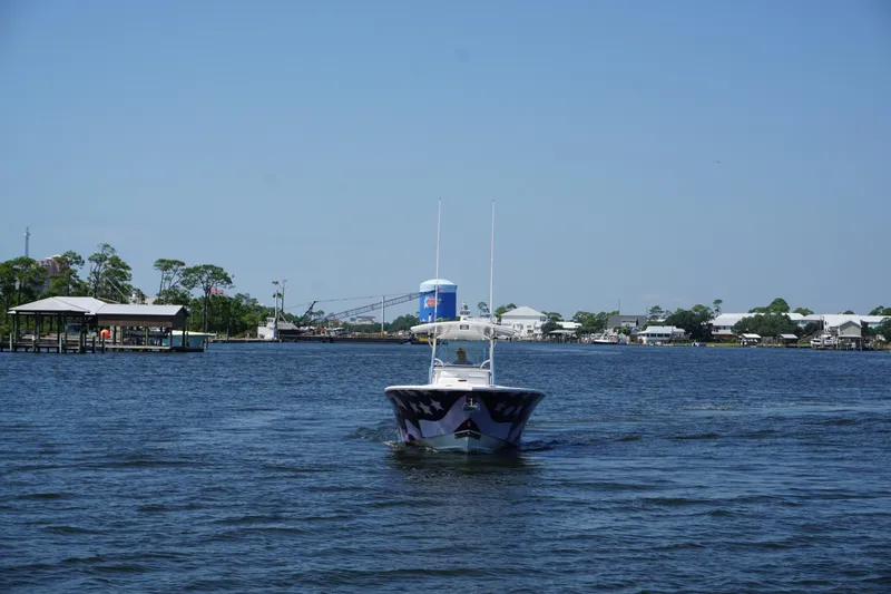 Past Time Yacht Photos Pics 2012 Regulator 32 Forward Seating boat cruising on a calm river under clear blue skies.