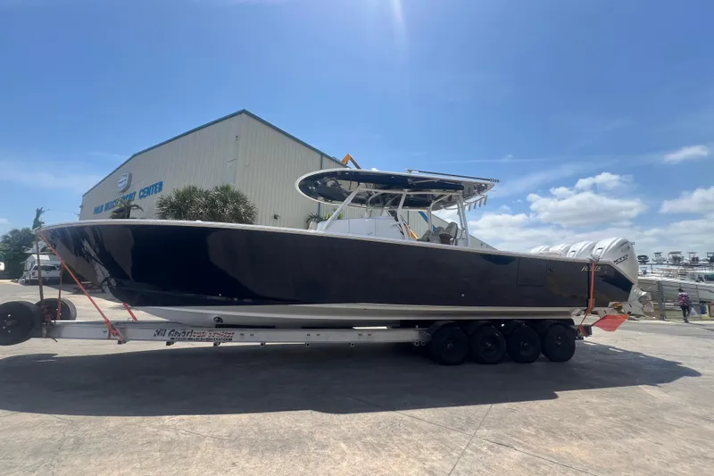 Madnic Yacht Photos Pics 2025 Jupiter 43 boat on trailer at marina under clear blue sky.