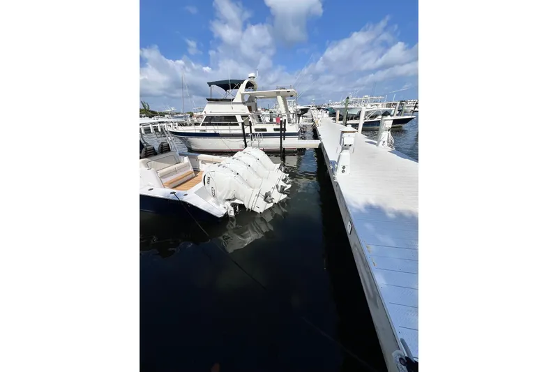 Madnic Yacht Photos Pics Docked 2025 Jupiter 43 boat with triple outboard engines under a clear blue sky.
