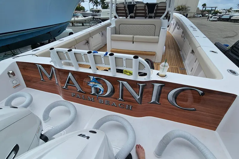 Madnic Yacht Photos Pics 2025 Jupiter 43 boat with "MADNIC" branding, docked at Palm Beach marina.
