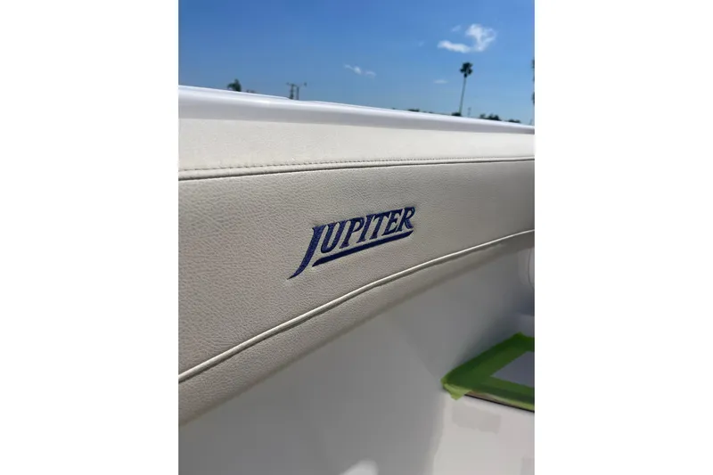 Madnic Yacht Photos Pics 2025 Jupiter 43 boat interior with logo, featuring sleek white upholstery under a clear blue sky.