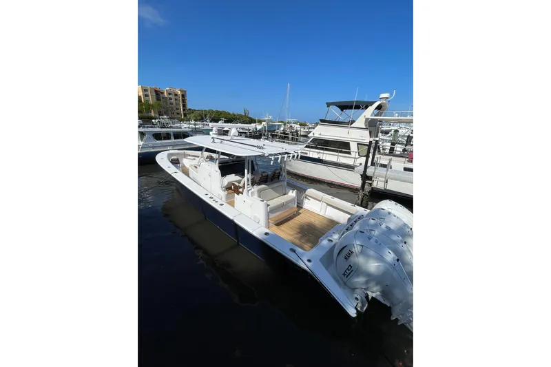 Madnic Yacht Photos Pics 2025 Jupiter 43 boat docked at marina under clear blue sky.