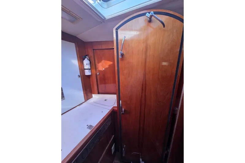 Pemaquid Yacht Photos Pics Interior of 1998 Oyster 485 Deck Saloon yacht with wooden cabinetry and fire extinguisher.