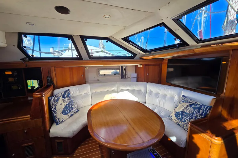 Pemaquid Yacht Photos Pics Luxurious interior of 1998 Oyster 485 Deck Saloon yacht with plush seating and wooden table.
