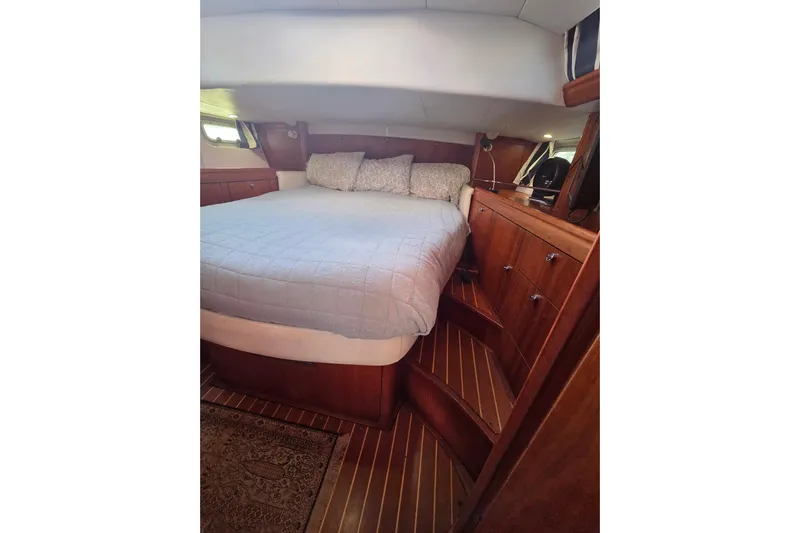 Pemaquid Yacht Photos Pics Luxurious cabin interior of 1998 Oyster 485 Deck Saloon yacht with cozy bed and wooden furnishings.