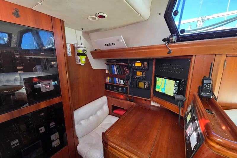 Pemaquid Yacht Photos Pics Navigation station inside 1998 Oyster 485 Deck Saloon yacht, featuring control panels and equipment.