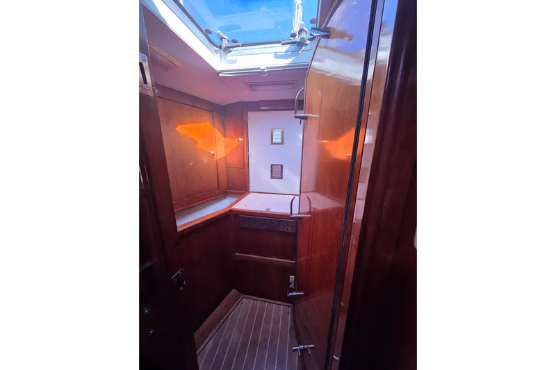 Pemaquid Yacht Photos Pics Interior of 1998 Oyster 485 Deck Saloon yacht, featuring wooden cabinetry and skylight.