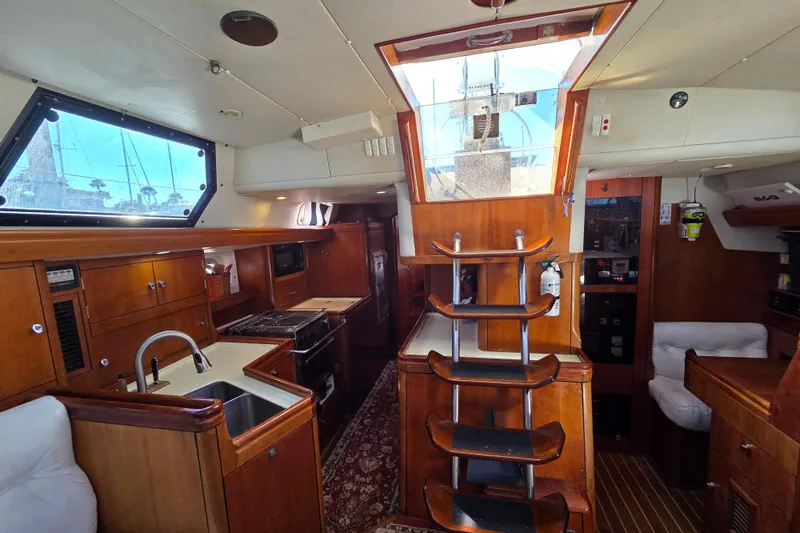 Pemaquid Yacht Photos Pics Interior of 1998 Oyster 485 Deck Saloon yacht with wooden cabinetry and modern amenities.