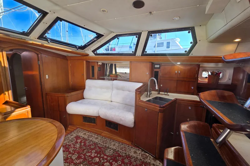Pemaquid Yacht Photos Pics Luxurious interior of 1998 Oyster 485 Deck Saloon yacht with plush seating and elegant wood finishes.