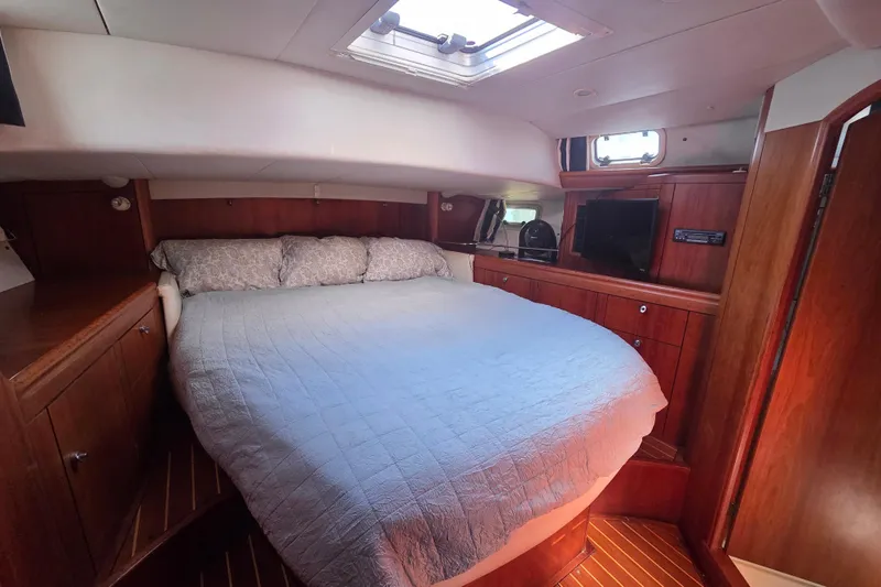 Pemaquid Yacht Photos Pics Luxurious cabin interior of 1998 Oyster 485 Deck Saloon yacht with cozy bed and wood finish.