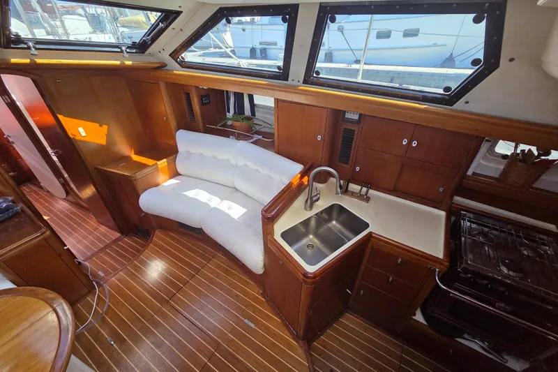 Pemaquid Yacht Photos Pics Interior of 1998 Oyster 485 Deck Saloon yacht with white sofa and kitchenette.