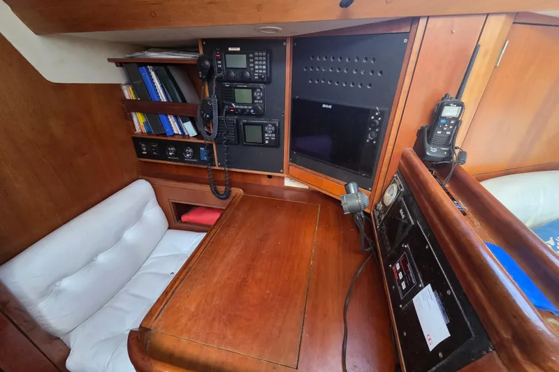 Pemaquid Yacht Photos Pics Navigation station of 1998 Oyster 485 Deck Saloon with communication equipment and wooden interior.