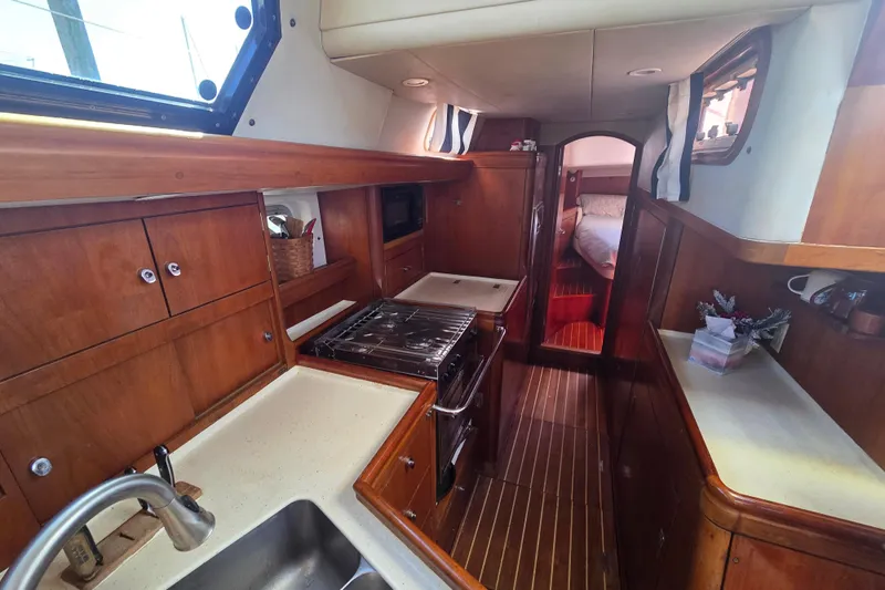 Pemaquid Yacht Photos Pics Interior of 1998 Oyster 485 Deck Saloon yacht, featuring a wooden galley and cozy cabin.
