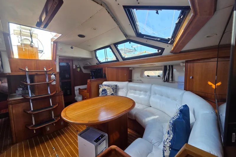 Pemaquid Yacht Photos Pics Luxurious interior of 1998 Oyster 485 Deck Saloon yacht with white seating and wooden finishes.
