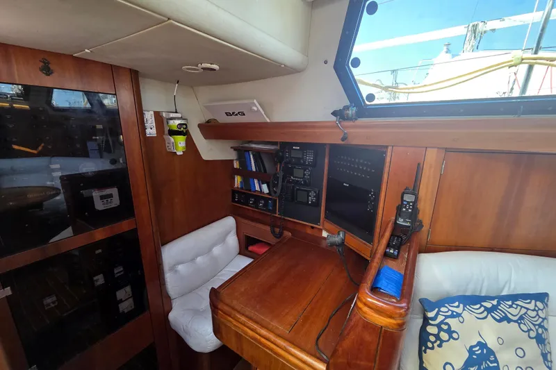 Pemaquid Yacht Photos Pics Interior of 1998 Oyster 485 Deck Saloon with navigation equipment and wooden furnishings.