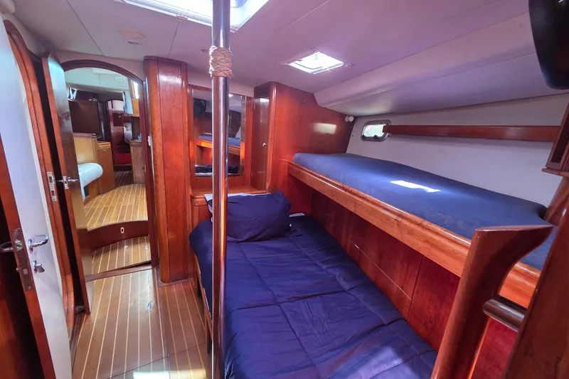 Pemaquid Yacht Photos Pics Interior of 1998 Oyster 485 Deck Saloon yacht with wooden finishes and cozy sleeping area.