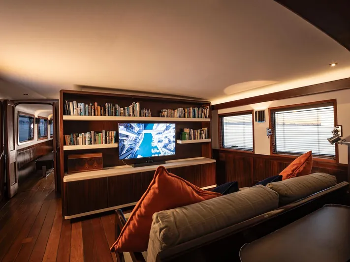 La Fenice Yacht Photos Pics Luxurious salon on 1962 Laurent Giles yacht with bookshelf and TV.