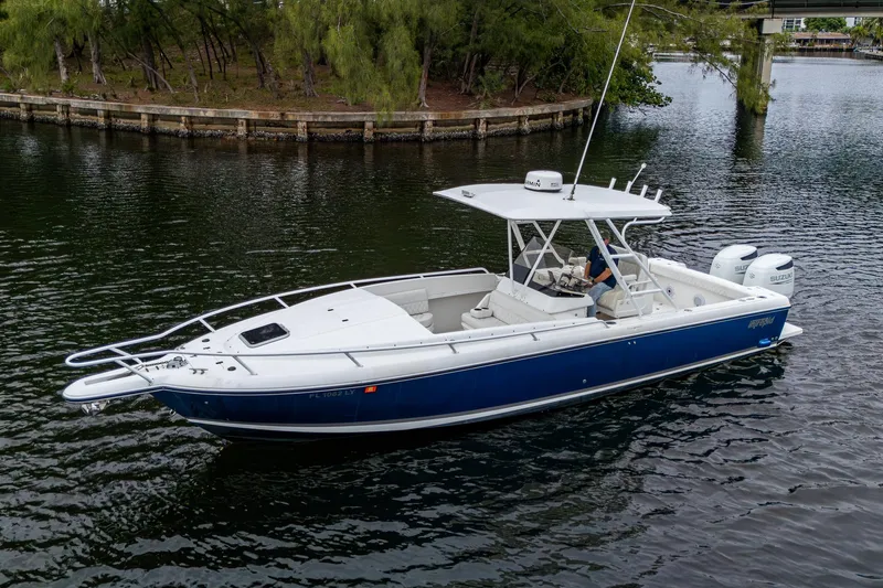  Yacht Photos Pics 2003 Intrepid 32 boat on calm water, featuring a sleek blue and white design.