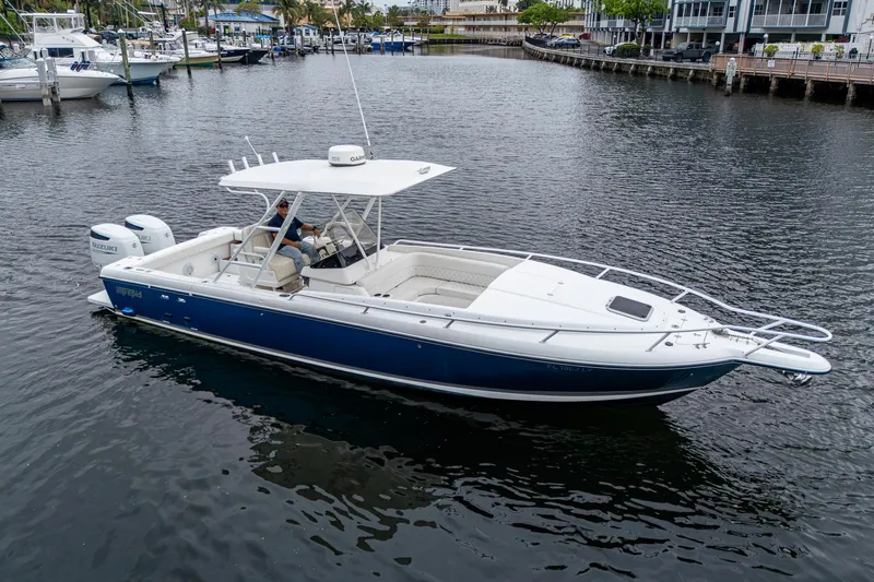  Yacht Photos Pics 2003 Intrepid 32 boat on calm water, featuring a sleek blue and white design.