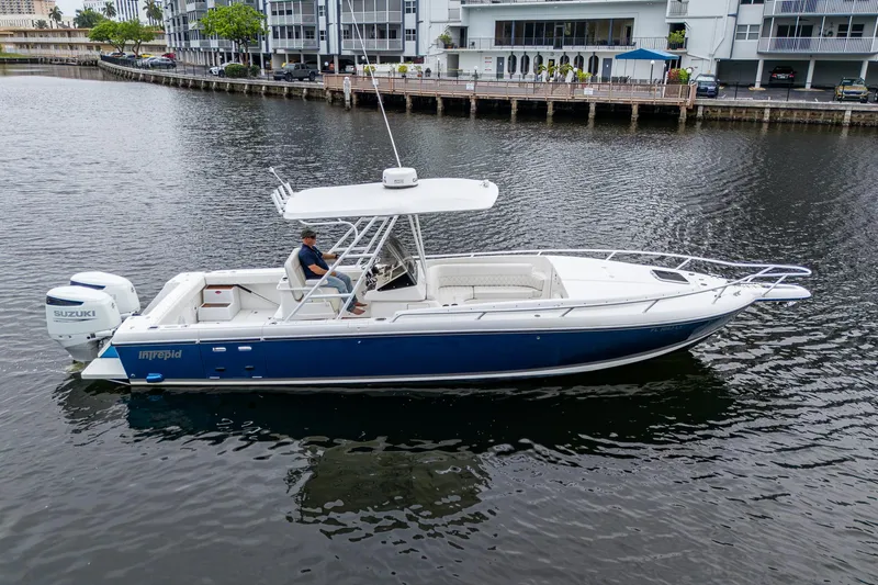  Yacht Photos Pics 2003 Intrepid 32 boat on calm water, featuring a sleek blue and white design.