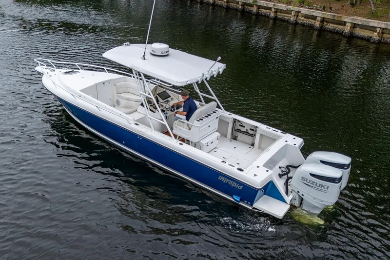  Yacht Photos Pics 2003 Intrepid 32 boat with dual Suzuki engines cruising on a calm waterway.