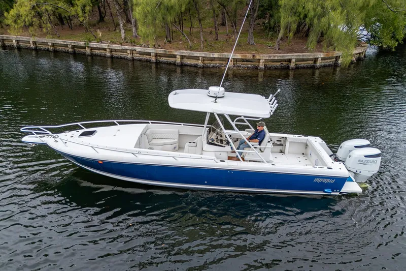  Yacht Photos Pics 2003 Intrepid 32 boat on calm water, featuring a sleek blue and white design.