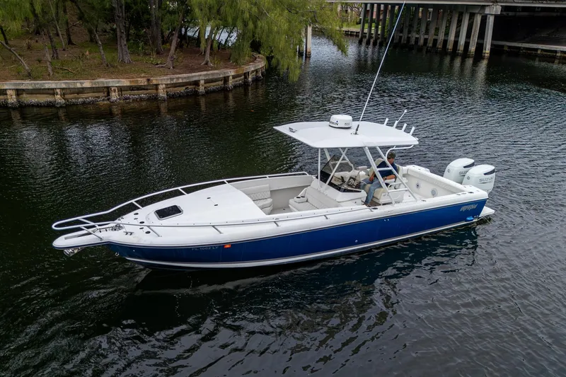  Yacht Photos Pics 2003 Intrepid 32 boat with blue hull cruising on a calm waterway.