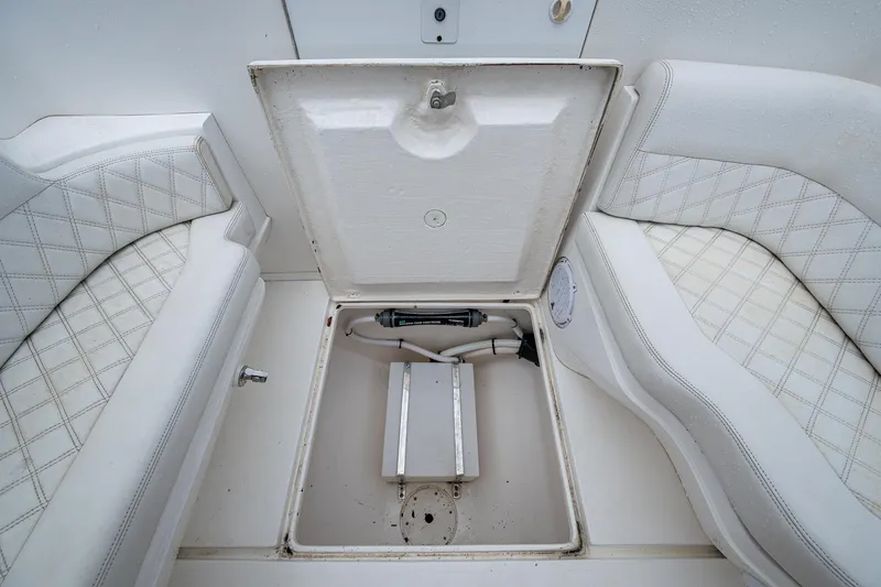  Yacht Photos Pics 2003 Intrepid 32 boat storage compartment with open hatch and cushioned seating.