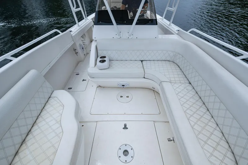  Yacht Photos Pics 2003 Intrepid 32 boat interior with white cushioned seating and open deck layout.