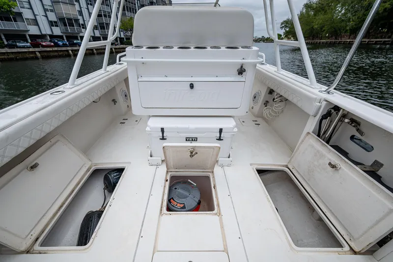  Yacht Photos Pics 2003 Intrepid 32 boat interior with storage compartments and seating, docked by the water.