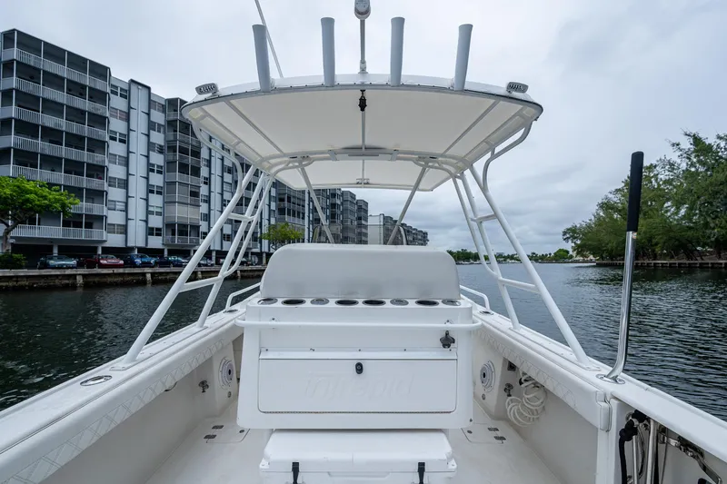  Yacht Photos Pics 2003 Intrepid 32 boat on water near modern buildings and trees.