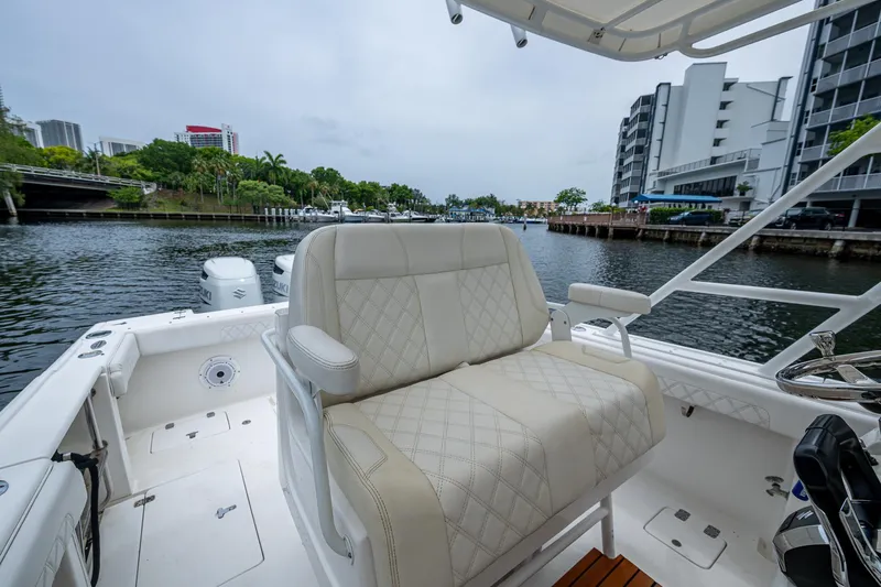  Yacht Photos Pics 2003 Intrepid 32 boat interior with cushioned seating, docked near waterfront buildings.