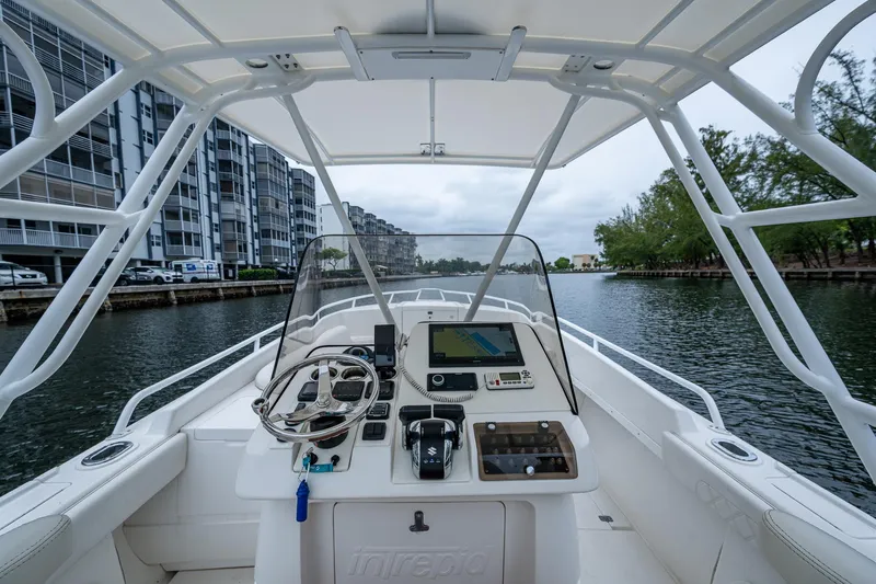  Yacht Photos Pics 2003 Intrepid 32 boat navigating a canal, featuring modern controls and a sleek design.
