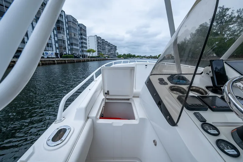  Yacht Photos Pics 2003 Intrepid 32 boat on water near modern buildings, featuring open storage compartment.