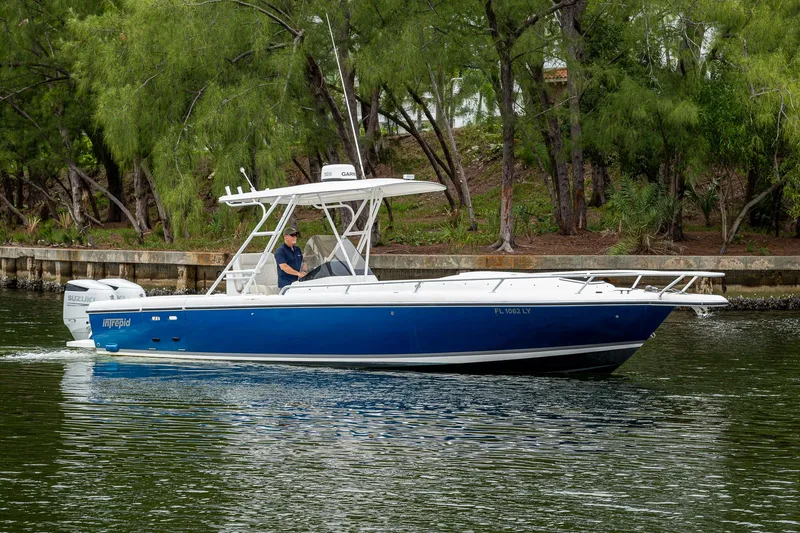  Yacht Photos Pics 2003 Intrepid 32 boat cruising on a calm waterway with lush greenery.