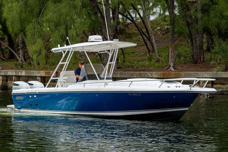  Yacht Photos Pics 2003 Intrepid 32 boat cruising on a calm waterway with lush greenery in the background.