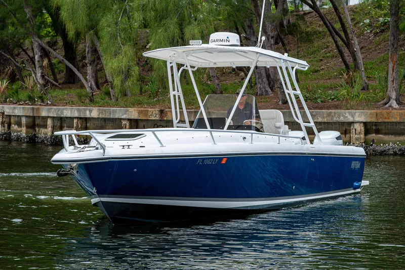  Yacht Photos Pics 2003 Intrepid 32 boat on water, featuring a sleek blue hull and white canopy.