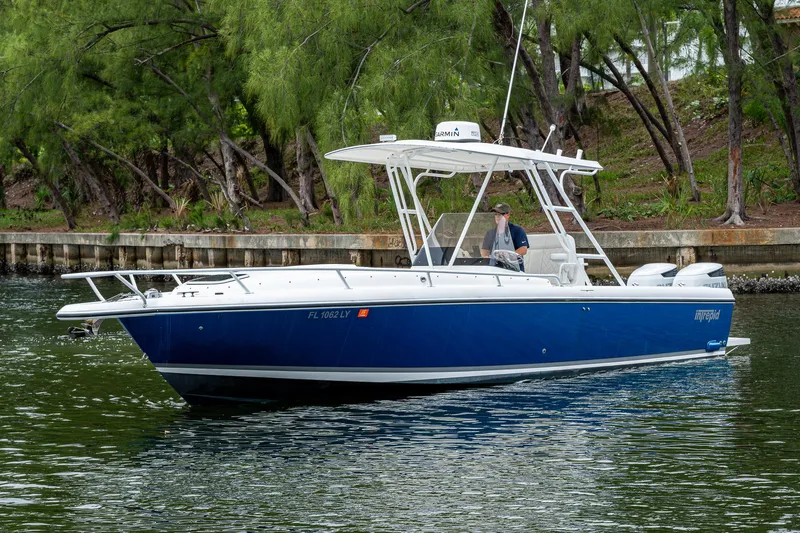  Yacht Photos Pics 2003 Intrepid 32 boat cruising on a calm waterway with lush greenery.