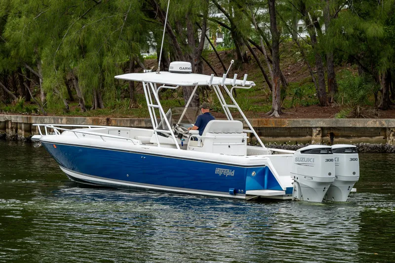  Yacht Photos Pics 2003 Intrepid 32 boat cruising on a calm waterway with lush greenery.