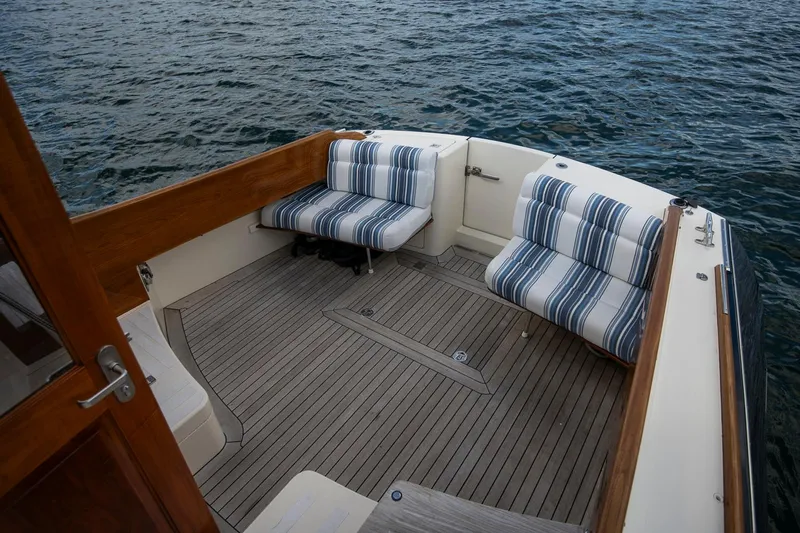 Halcyon Yacht Photos Pics Hinckley Talaria 44 FB 2006 boat deck with striped seating, overlooking water.