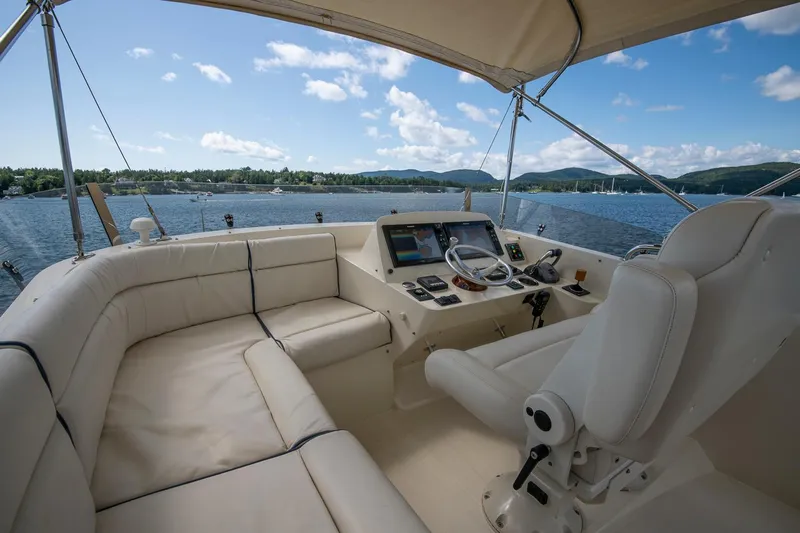 Halcyon Yacht Photos Pics 2006 Hinckley Talaria 44 FB yacht cockpit with helm, white seating, and scenic water view.