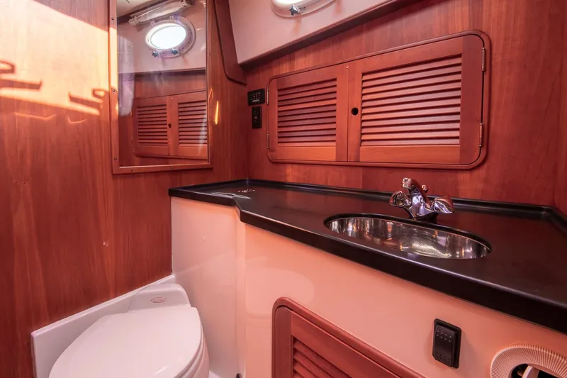 Halcyon Yacht Photos Pics 2006 Hinckley Talaria 44 FB yacht bathroom with wood cabinetry and stainless steel sink.