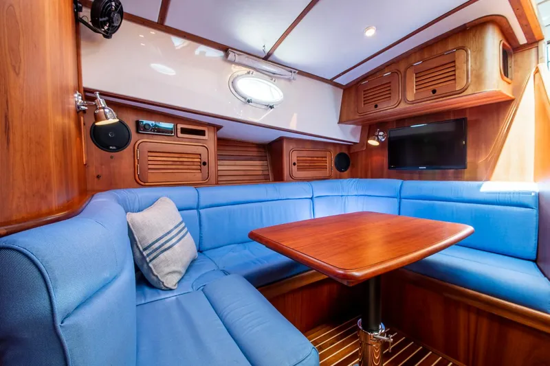 Halcyon Yacht Photos Pics Luxurious interior of 2006 Hinckley Talaria 44 FB yacht with blue seating and wooden accents.