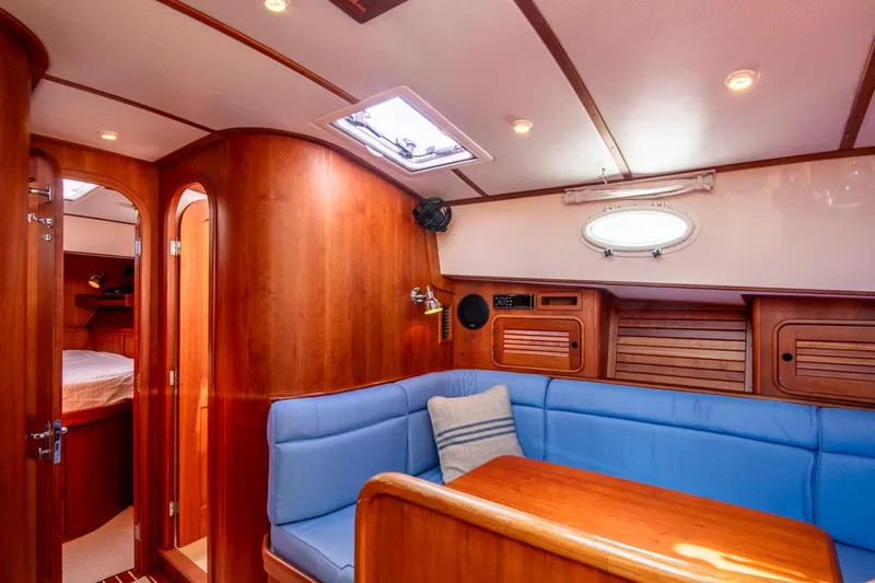 Halcyon Yacht Photos Pics Luxurious interior of 2006 Hinckley Talaria 44 FB yacht with blue seating and wood finish.