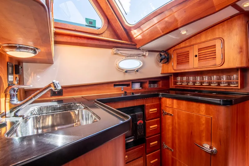 Halcyon Yacht Photos Pics Luxurious 2006 Hinckley Talaria 44 FB yacht kitchen with wood cabinetry and modern amenities.