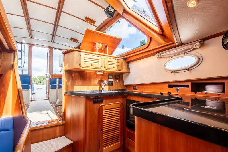 Halcyon Yacht Photos Pics Interior of 2006 Hinckley Talaria 44 FB yacht, featuring a wooden kitchen and skylight.