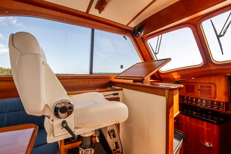 Halcyon Yacht Photos Pics Interior of 2006 Hinckley Talaria 44 FB yacht with captain's chair and wooden dashboard.