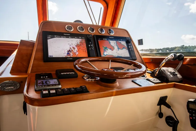 Halcyon Yacht Photos Pics Helm of 2006 Hinckley Talaria 44 FB with navigation screens and wooden steering wheel.